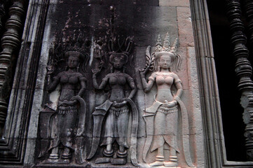 Fototapeta premium Sculpture carving figure apsaras or apsara angel deity female spirit of clouds and waters elegant and superb art of dancing in Hindu and Buddhist culture on wall of Angkor wat at Siem Reap, Cambodia
