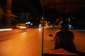 Naklejka premium Cambodia people riding motorcycle for service cambodian and foreign travelers send receive go to travel visit ancient ruins Khmer Empire of Angkor Wat city temple in morning at Siem Reap, Cambodia