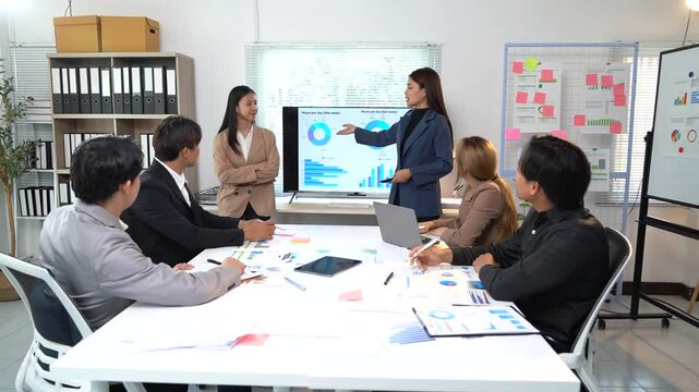 Professional business team analyzing financial data, discussing strategy with collaborative approach during corporate meeting in modern office workspace