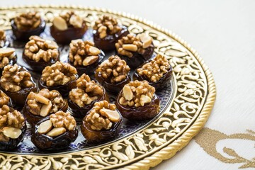 Fototapeta premium Nut-Stuffed Dates Dates filled with walnuts and almonds, arranged on a decorative plate.