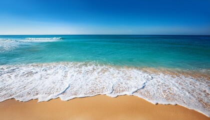 beautiful clear blue sea washing up onto golden sand