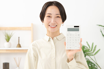 笑顔で電卓を持つ女性