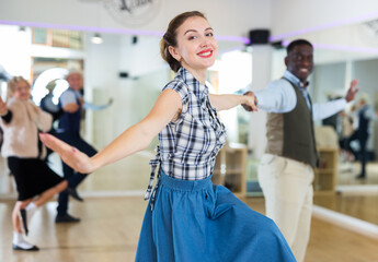 Cheerful female practicing lindy hop in pair with man
