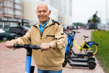 Portrait of elderly man with electric scooter on street