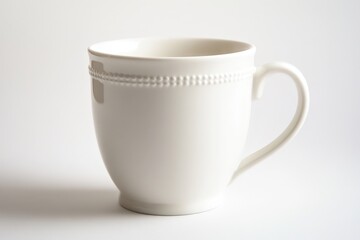 A white ceramic mug with a simple handle displayed in the light