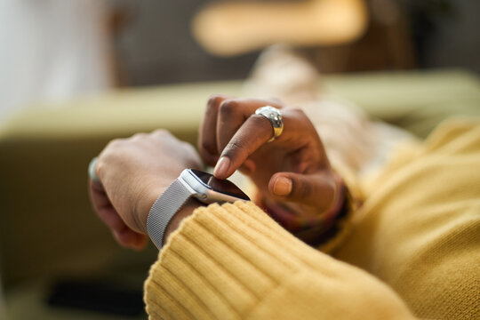 Close-up of person using smartwatch for checking time and notifications. Modern technology with blurred background and soft focus on hand and gadget