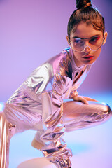 Futuristic woman showcasing vibrant holographic fashion in a creative urban setting