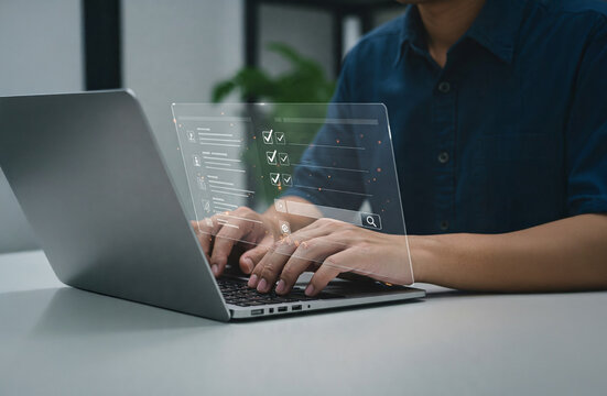 Man in blue shirt using a laptop with digital checklist overlay on a transparent screen in a modern office setting.