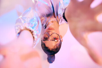 Stylish woman embraces vibrant holographic colors in futuristic fashion setting