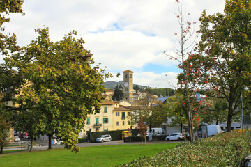 Naklejka premium A picturesque small town with a bell tower and green trees.
