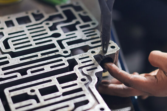 Close up hand repair Automatic transmission control center variator gearbox valve body, details of the automatic transmission oil line, iron labyrinth.