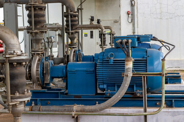 Close-up of industrial blue water pumps and a piping system at power-plant