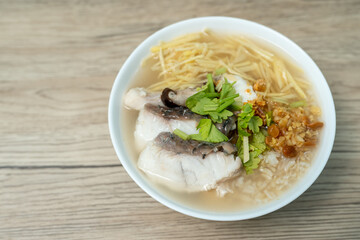 Brown rice and sea bass porridge, Sea bass congee on wooden background.