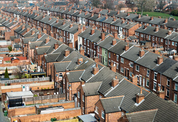 Aerial view above rows of back to back terraced houses on a large council estate