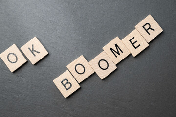 OK boomer, wooden blocks with letters on black background.