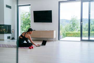 Fototapeta premium Young Beautiful Female Woman with Trainer via Video Call Conference in Bright Sunny House. Healthy Lifestyle, Wellbeing and Mindfulness Concept