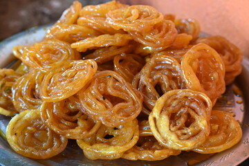 Jalebi sweets. It is a popular sweet snack in India subcontinent. It is many names jilapi, jilebi, jilipi, zulbia, mushabak, z’labia and zalabia. Its made by maida flour batter and sugar syrup.