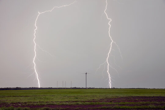 Lightning strikes over open field with antenna