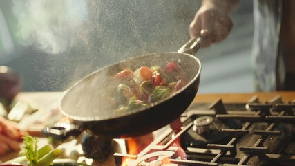 Slow-motion cinematic shot of a chef hand tossing multicolored vegetables in wok pan in restaurant kitchen - Powered by Adobe