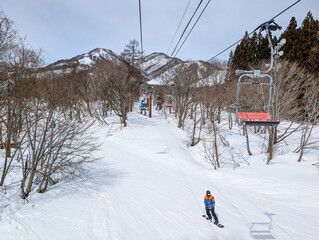 Snowboarder on a gentle ski slope at Hakuba in Nagano, Japan