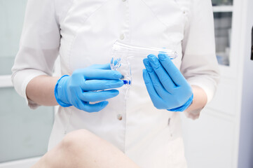 A doctor holding a gynecological speculum, gynecological examination, women's health care, regular...