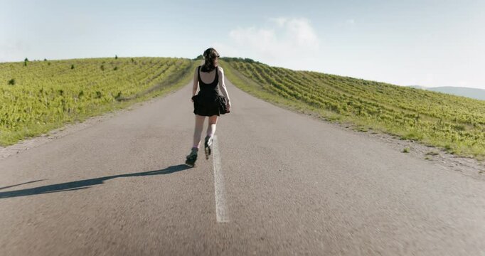 Young sporty woman riding and training on roller skates on the road