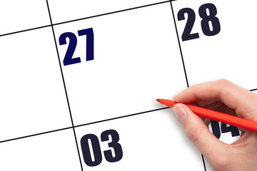 Calendar date 27. A hand holding a red pen is about to write text on an empty white calendar page...