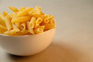 Pasta perfectly arranged in a white bowl on a simple backdrop