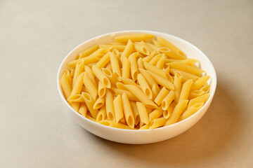 Freshly cooked penne pasta in a white bowl ready for delicious recipes