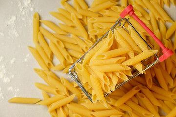 Pasta in a basket surrounded by scattered pieces on a kitchen counter
