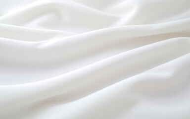 Naklejka premium A close-up view of soft, flowing white fabric showcasing delicate textures and gentle folds