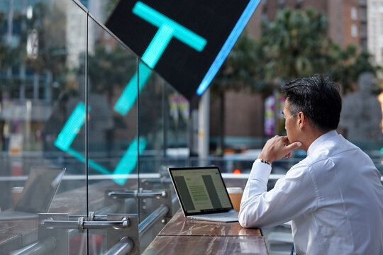 Asian businessman working on lap top in a cafe in the city