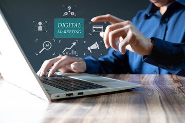 Businessman using laptop with virtual digital marketing icons for online sales and commerce concept, digital marketing, web advertising, social networking, display icons on virtual screen.