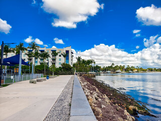 Miami, Florida - Feb 25, 2025: A scenic waterfront promenade at Albert Pallot Park offers views of Biscayne Bay and nearby buildings on a sunny day in Miami © Mdv Edwards
