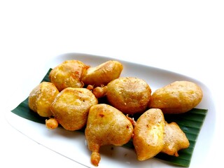 Sweet honey banana fritters on a white plate with banana leaf.