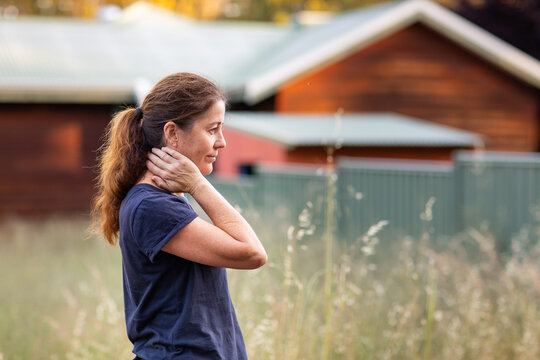 woman in profile outside weatherboard cottage in the country