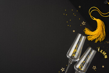 Graduation-themed image showcasing two champagne glasses, a golden graduation tassel, and scattered...