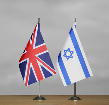 Table flags United Kingdom and Israel on grey blurred background