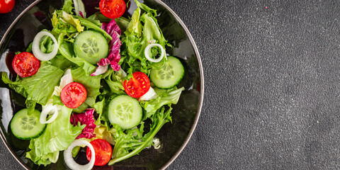 Vegetable salad tomato, cucumber, lettuce, green leaf lettuce, onion appetizer vegetable dish fresh gourmet food background rustic food top view copy space keto and paleo diet vegetarian vegan food