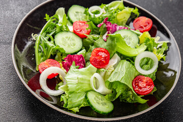 Vegetable salad tomato, cucumber, lettuce, green leaf lettuce, onion appetizer vegetable dish fresh gourmet food background rustic food top view copy space keto and paleo diet vegetarian vegan food
