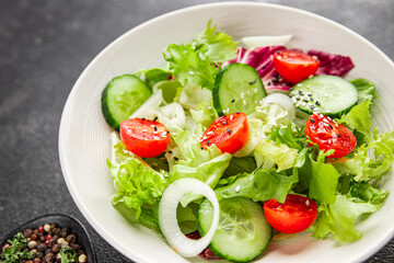 Vegetable salad tomato, cucumber, lettuce, green leaf lettuce, onion appetizer vegetable dish fresh gourmet food background rustic food top view copy space keto and paleo diet vegetarian vegan food