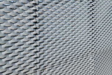 modern texture with galvanized steel useful anti-rust. Detail of a building facade in expanded metal panels of steel composed of modular elements perforated and elongated to make it stronger