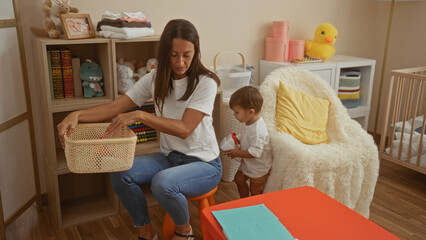 Woman organizing basket with son in cozy bedroom filled with toys and books, showcasing a warm family atmosphere indoors at home.