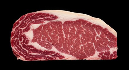 Close up shot showing a raw ribeye steak with visible marbling against a black background isolated