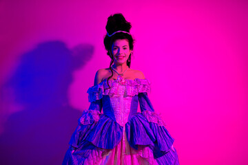 Portrait of a young woman in elegant baroque costume illuminated by neon pink lighting, evoking historical and modern artistic styles.