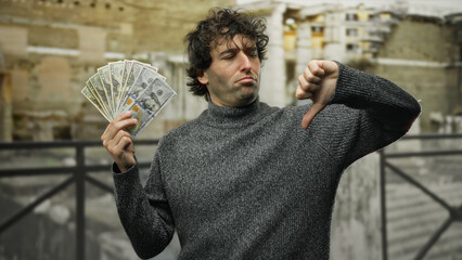 Hispanic man expressing dissatisfaction while holding american dollars on a city street,...
