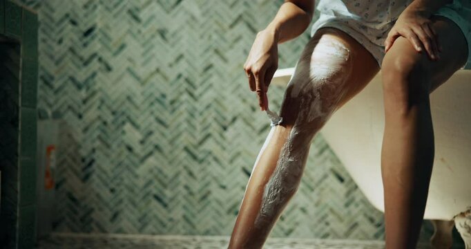 Bathroom, shaving and legs of woman in morning for cleaning, wellness and grooming in home. Skincare, beauty and person with razor, foam and cosmetics for epilation, hair removal and smooth skin