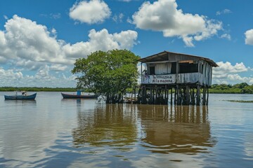 Obraz premium A wooden house is built above the river waters