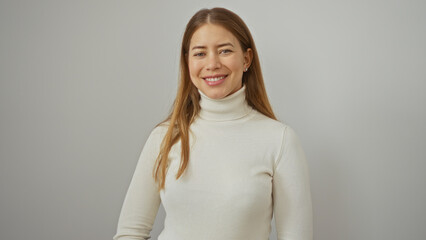 Obraz premium Woman smiling confidently against a plain white background wearing a cozy sweater emphasizing her youthful beauty and relaxed demeanor.