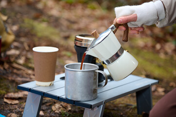 Outdoor moka coffee set on picnic table and camping in the forest. Moka pot coffee on outdoor...